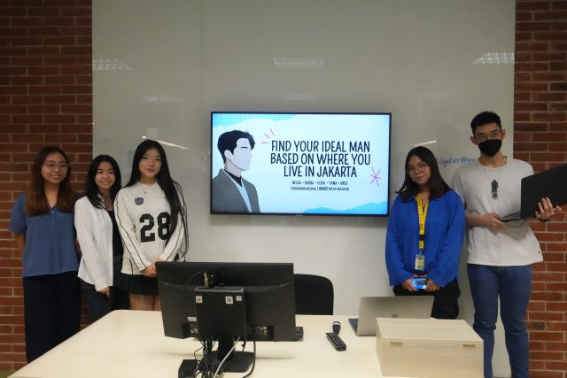 Students pose in front of a screen showing their Data Storytelling project title